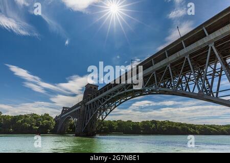 Il Ponte Britannia dalla costa dello stretto di Menai a bassa marea, Anglesey, Galles del Nord Foto Stock