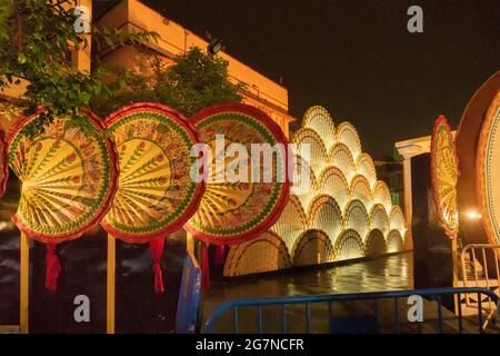 KOLKATA , INDIA - 28 SETTEMBRE 2017 : immagine notturna del pandal Durga Puja decorato con vecchi disegni esterni del Bengalese con grandi ventilatori fatti di palmyra Foto Stock