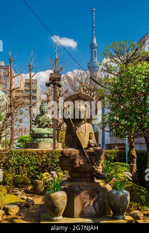 Giappone tra tradizione e modernità. Preghiera Buddha antiche statue vicino al tempio di Asakusa con il nuovo Tokyo Skytree sullo sfondo Foto Stock