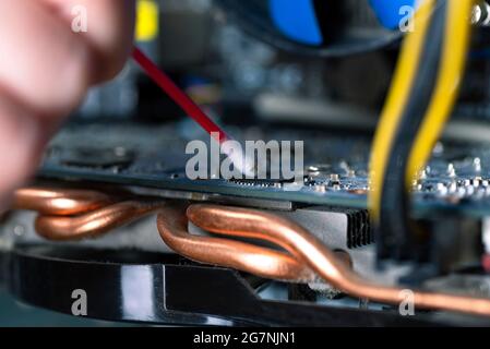 Parti interne di un vecchio personal computer. Scheda madre e scheda video polverose. La procedura guidata pulisce la scheda video. PC rotto Foto Stock