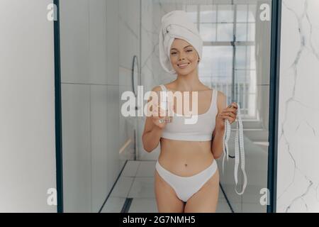 Donna sottile e attraente felice che si gode la routine mattutina a casa Foto Stock