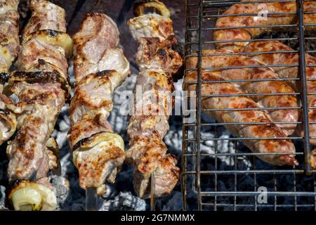 Salsicce di carne alla griglia. Cottura della carne alla griglia. Barbecue. Primo piano. Messa a fuoco selettiva. Foto Stock