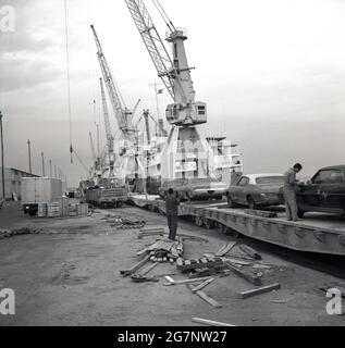 Anni Sessanta, storici, alle banchine della città portuale di Jeddah, Arabia Saudita, automobili americane parcheggiate su una ferrovia che vengono importate nel paese, Foto Stock