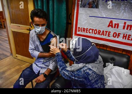 Srinagar, India. 15 luglio 2021. Un operatore sanitario vaccina un uomo vaccinato con il vaccino Covisield Coronavirus durante la campagna di vaccinazione. Il ritmo delle vaccinazioni giornaliere in tutta l'India ha di nuovo iniziato a rallentare. Il paese ha iniziato l'ultima fase della sua guida di inoculazione in cui il Centro fornisce gratuitamente colpi a tutti gli stati. Credit: SOPA Images Limited/Alamy Live News Foto Stock