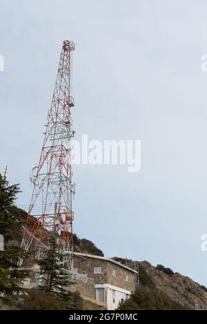 Torre per telecomunicazioni su un edificio con antenna 4G 5G e antenna satellitare contro il cielo blu. Comunicazioni mobili Foto Stock