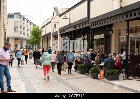 Le persone che indossano maschere di protezione che acquistano su Abbey Street a Tralee, County Kerry, Irlanda a partire da giugno 2021 Foto Stock