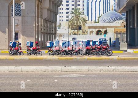 Servizio di consegna di cibo negli Emirati Arabi Uniti. Gruppo di motociclette parcheggiate in un parcheggio speciale sulla strada in attesa dell'ordine e della consegna ai clienti. Foto Stock