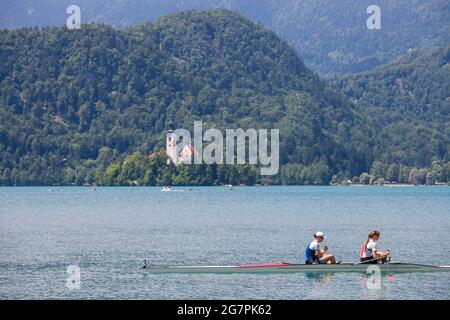 Foto di due giovani donne adulte, formazione su un paio senza coxless sul lago di Bled, in Slovenia. Un paio senza coxless è una barca a remi utilizzata nello sport della competizione Foto Stock