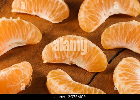 Satsuma Mandarino Tangerine frutta cunei su legno naturale (Citrus unshiu) Foto Stock