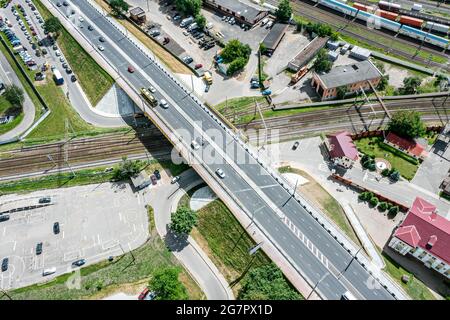 vista aerea del ponte stradale e dei binari ferroviari. intersezione stradale nel quartiere industriale urbano. Foto Stock