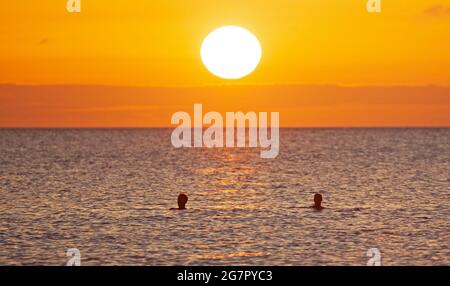 Portobello, Edimburgo, Scozia, Regno Unito. 16 luglio 2021. Alba bellezza al mare. Temperatura 14 gradi. Questa coppia gode di un tuffo all'alba nel Firth of Forth. Credit: Arch White/Alamy Live News. Foto Stock