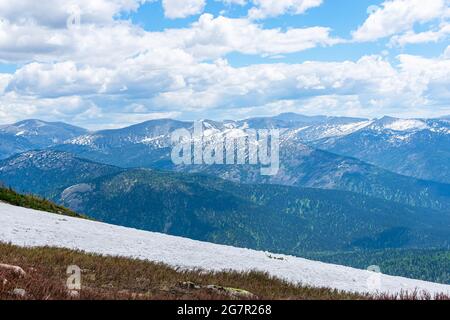Cime innevate di mezza montagna e nuvole basse sopra la cresta Foto Stock