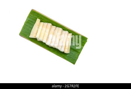 Isolato affettato giovani germogli di cocco su vassoio foglia di banana, vista dall'alto immagine su sfondo bianco. Germogli di cocco biologici per cucinare in Asia o Thailandia Foto Stock