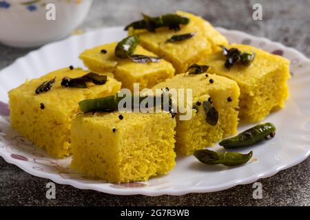 Fuoco selettivo sulla dhokla gialla, un alimento indiano servito in un piatto Foto Stock