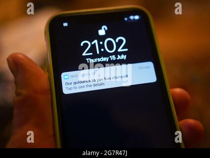 Una notifica emessa dall'app di tracciamento dei contatti di NHS coronavirus - che informa una persona di un cambiamento nella guida - viene visualizzata su un telefono cellulare a Londra, durante l'allentamento delle restrizioni di blocco in Inghilterra. Data immagine: Venerdì 16 luglio 2021. Foto Stock