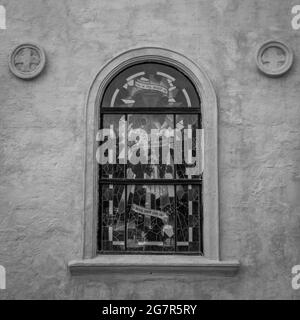 Immagine verticale in scala di grigi di una finestra di una chiesa ad arco Foto Stock