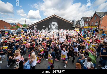 File foto datata 13/07/21 di persone che prendono il ginocchio davanti ad un murale di attaccante Manchester United e del giocatore inglese Marcus Rashford su Copson Street, Withington. La polizia ha detto che non pensano che i graffiti abusivi sul murale fossero di natura razziale. Data di emissione: Venerdì 16 luglio 2021. Foto Stock