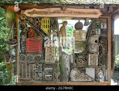 13 luglio 2021, Sassonia-Anhalt, Holzdorf-Jessen: Un hotel di insetti si trova nel 'Giardino della Foresta aperta' di circa 5,000 metri quadrati di forestieri e educatore della foresta Detlef Schulz. È una delle molte figure grandi e piccole scolpite e disegnate, animali e spiegazioni nel giardino aperto, che non ha recinzione. Per 40 anni Detlef Schulze ha apprezzato la sua oasi di benessere, che può essere esplorata dai visitatori in qualsiasi momento. Foto: Waltraud Grubitzsch/dpa-Zentralbild/ZB Foto Stock