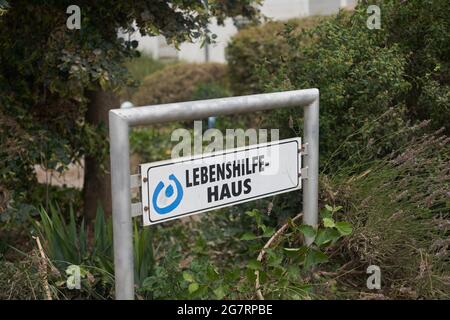 Sinzig, Germania. 16 luglio 2021. Il cartello di fronte alla casa di Lebenshilfe per i disabili. La pioggia pesante ha anche portato a un'inondazione estrema qui. A causa del rapido aumento dell'acqua, dodici persone non potevano più essere salvate dalle inondazioni dell'Ahr. Credit: Thomas Frey/dpa/Alamy Live News Foto Stock