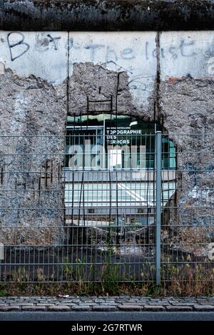 Topografia del museo del terrore visto attraverso il foro nei resti del muro di Berlino in Niederkirchnerstrasse, Kreuzberg, Berlino Foto Stock