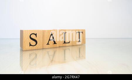 La parola sale è stata creata da cubetti di lettere di legno. Gastronomia e spezie. Primo piano. Foto Stock