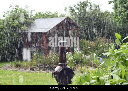 Pioggia torrenziale in una giornata estiva in un giardino di campagna inglese Foto Stock