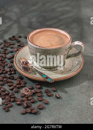 Caffè e chicchi di caffè profumati e forti su fondo di cemento verde scuro. Il concetto di bevande calde. Copiare spazio per il testo Foto Stock