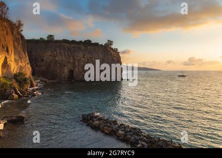 Splendido tramonto sul mare accanto alla spiaggia e alle alte scogliere Foto Stock