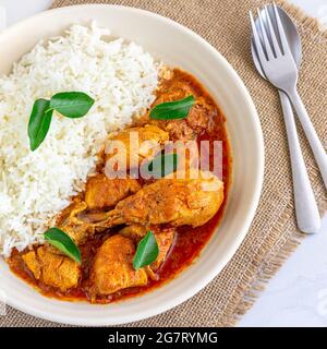 Curry di pollo guarnito con foglie di Curry Top Down orizzontale Foto su sfondo bianco Foto Stock