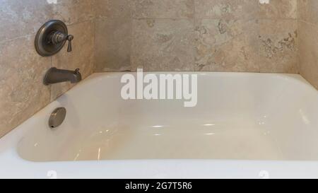 Pano piccolo bagno con vasca in ceramica e doccia a parete con rubinetto Foto Stock
