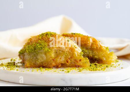 Sobiyet baklava con pistacchio su sfondo bianco di legno. Baklava su pavimento in marmo. Foto Stock