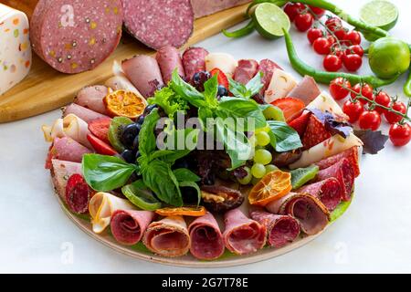 Piatto di carne su fondo bianco di legno. Set di Salami. Salumi di diversi tipi di carne. Piatto con set di antipasti, snack plat di carne, vista orizzontale Foto Stock