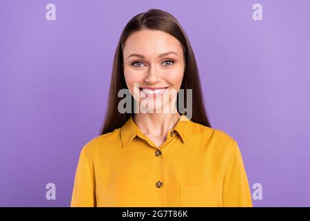 Ritratto fotografico di donna sorridente indossando una camicia gialla isolata su sfondo color viola pastello Foto Stock