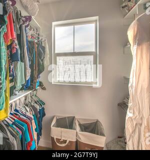 Cornice quadrata completa piccola passeggiata in armadio con finestra e cestini di lavanderia Foto Stock