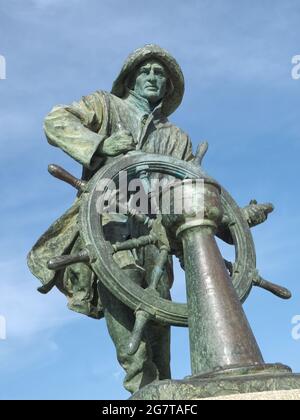 Statua in bronzo di un marinaio con una ruota Foto Stock