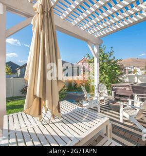 Cornice quadrata esterno patio vuoto di una casa e un tavolo che ha un ombrello chiuso. Foto Stock