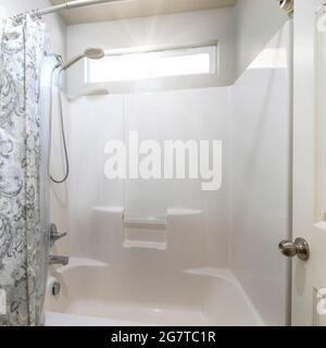 Doccia a cornice quadrata e vasca da bagno all'interno di un bagno con tenda  doccia Foto stock - Alamy