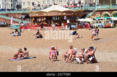 Brighton UK 16 luglio 2021 - Brighton Beach è occupato con i bagnanti in una giornata di sole caldo come il tempo caldo è previsto per continuare nei prossimi giorni in Gran Bretagna con le temperature previste per raggiungere gli alti 20 nel corso del fine settimana : Credit Simon Dack / Alamy Live News Foto Stock