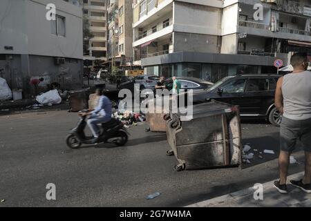 I bidoni spazzatura e le gomme brucianti bloccano le strade di Beirut dopo le dimissioni del primo ministro designato Saad Hariri, mentre la crisi libanese è aumentata giovedì (luglio 15).il primo ministro designato, Saad Hariri, è calato dopo non aver formato un governo negli ultimi otto mesi. La Lira libanese ha anche preso un naso come Hariri ha annunciato le dimissioni, scendendo da 19,500 LBP a 21,500 LBP per dollaro (secondo le app di tasso di cambio non ufficiali). Fino al novembre 2019, la Lira libanese è stata ancorata a 1,500 LBP per dollaro. Foto Stock