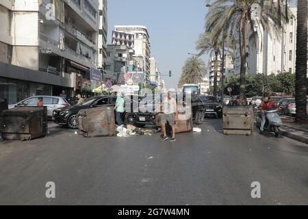 I bidoni spazzatura e le gomme brucianti bloccano le strade di Beirut dopo le dimissioni del primo ministro designato Saad Hariri, mentre la crisi libanese è aumentata giovedì (luglio 15).il primo ministro designato, Saad Hariri, è calato dopo non aver formato un governo negli ultimi otto mesi. La Lira libanese ha anche preso un naso come Hariri ha annunciato le dimissioni, scendendo da 19,500 LBP a 21,500 LBP per dollaro (secondo le app di tasso di cambio non ufficiali). Fino al novembre 2019, la Lira libanese è stata ancorata a 1,500 LBP per dollaro. Foto Stock