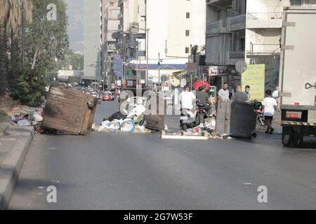 I bidoni spazzatura e le gomme brucianti bloccano le strade di Beirut dopo le dimissioni del primo ministro designato Saad Hariri, mentre la crisi libanese è aumentata giovedì (luglio 15).il primo ministro designato, Saad Hariri, è calato dopo non aver formato un governo negli ultimi otto mesi. La Lira libanese ha anche preso un naso come Hariri ha annunciato le dimissioni, scendendo da 19,500 LBP a 21,500 LBP per dollaro (secondo le app di tasso di cambio non ufficiali). Fino al novembre 2019, la Lira libanese è stata ancorata a 1,500 LBP per dollaro. Foto Stock