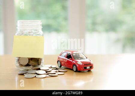 Concetto di budget per l'istruzione. Risparmio di denaro in auto in un bicchiere Foto Stock