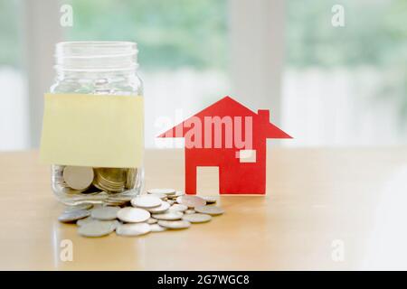 Education budget concept. risparmio di denaro a casa in un bicchiere Foto Stock