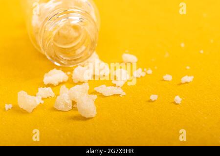 cristalli di sale narcotico anfetamina su sfondo giallo. Foto Stock