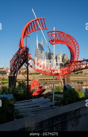 Nashville, Tennessee - 28 giugno 2021: Balletto fantasma per la East Bank Machine Works scultura incornicia lo skyline di Nashville Foto Stock