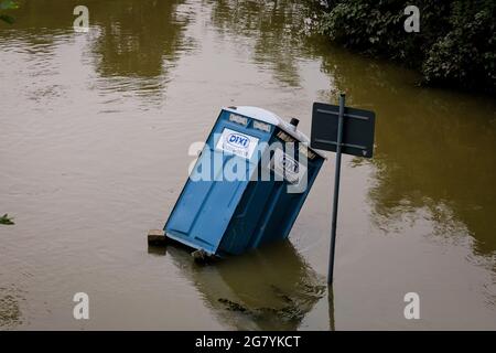 Hattingen, NRW, Germania. 16 luglio 2021. Una toilette portatile 'dixi' è crollata ed è circondata da acque alluvionali. Il fiume Ruhr ha allagato i suoi argini, campi e molti giardini, seminterrati e proprietà vicino alla città di Hattingen, nel quartiere Ruhr nella Renania Settentrionale-Vestfalia. Il NRW è stato colpito da terribili inondazioni, a seguito di forti piogge negli ultimi giorni. Più di 80 persone sono morte finora nelle inondazioni in Germania. Credit: Imageplotter/Alamy Live News Foto Stock