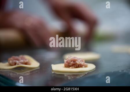 la fase di cottura di gnocchi con carne. impasto con carne macinata. Foto Stock