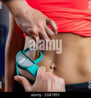 Misurazione del grasso della pancia con il test di piegatura della pinza Foto Stock