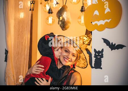 Halloween abiti su madre e figlio e strega costumi e cappelli strega. La caramella più popolare per Halloween. Halloween testa di zucca jack lanterna con Foto Stock