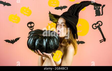 Abiti e costumi di Halloween e cappelli di strega. Halloween felice. Donna sorridente felice sullo sfondo di Halloween. Happy Halloween adesivi. Foto Stock